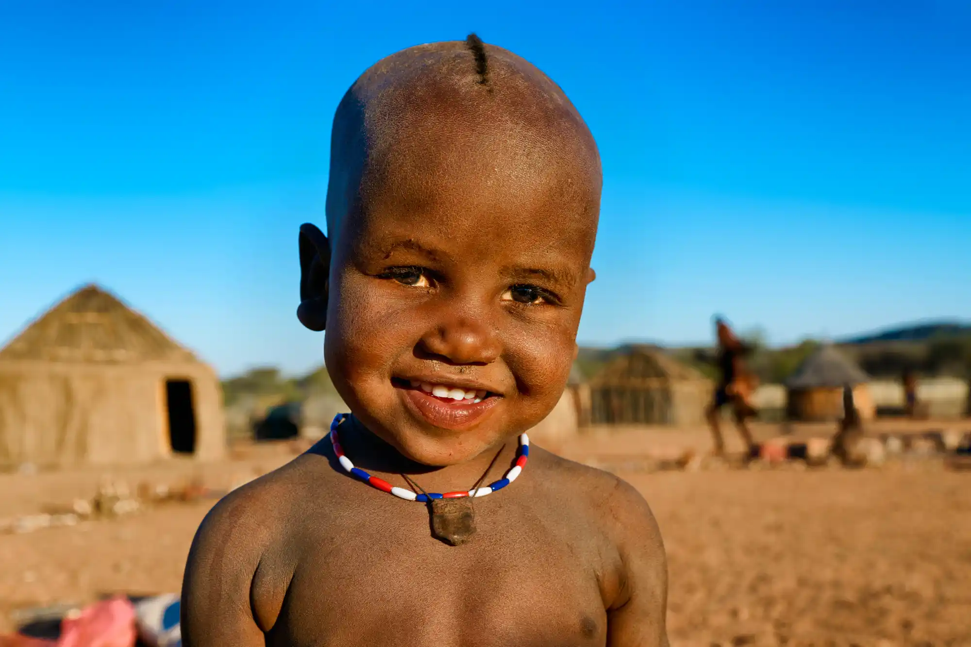 ein himba-kind fotografiert auf einer fotoreise in namibia bei einer fotoreise mit benny rebel fotosafaris.